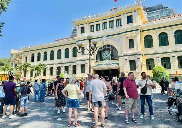 Иностранные посетители в знаменитом центральном почтовом отделении города Хошимин в районе 1. (Фото: ВИA)