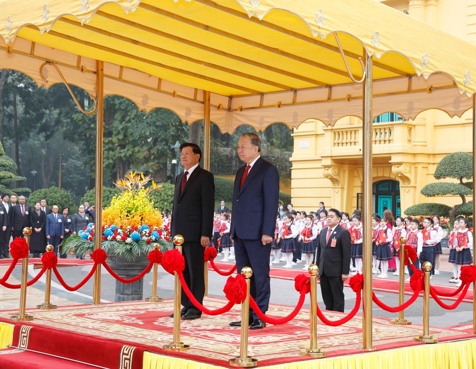 Генеральный секретарь То Лам и Генеральный секретарь, Президент Лаоса Тхонглун Сисулит на почётной трибуне во время церемонии исполнения государственного гимна. Фото: ВИА.