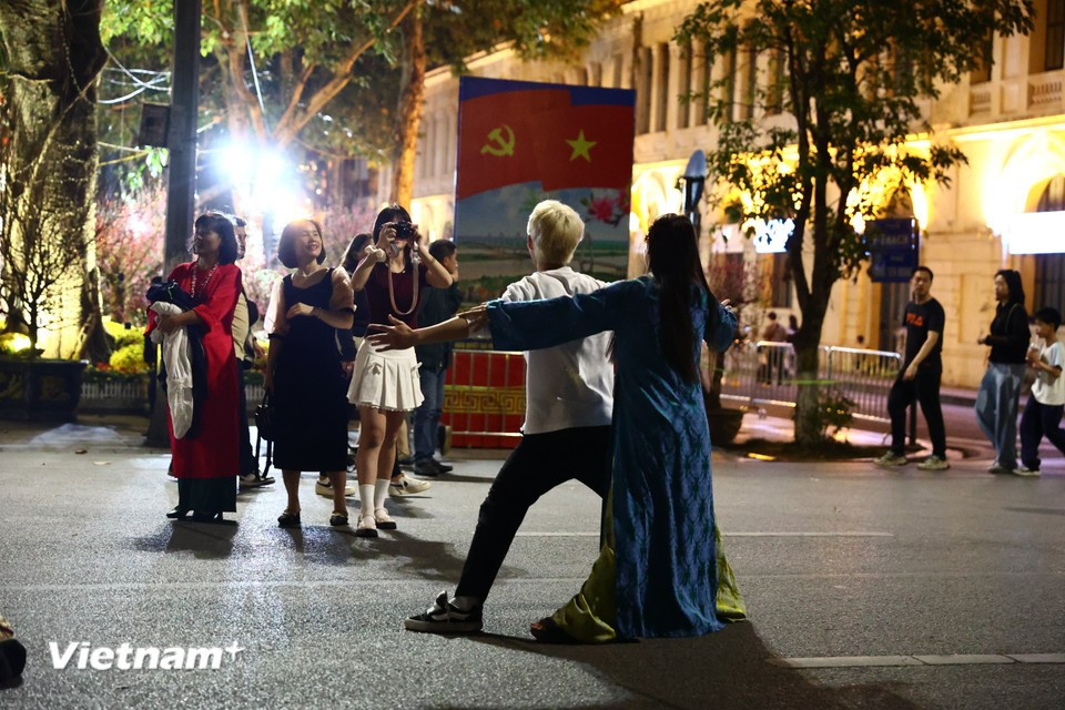 Жители в традиционных аозай танцуют на пешеходной зоне у озера Хоанкием. Фото: Vietnam+.