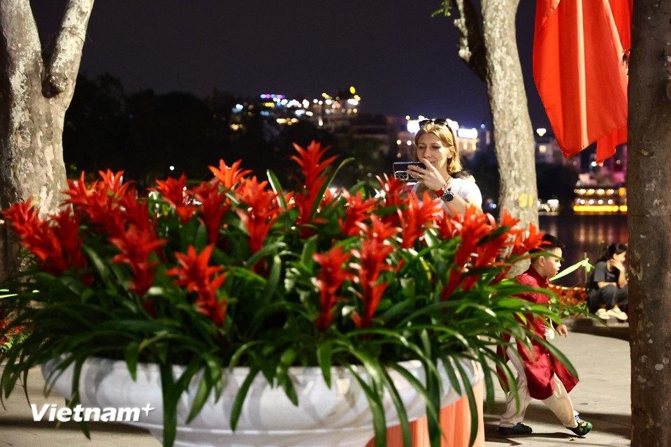 Туристы с интересом запечатлевают повседневные сцены на самой оживлённой пешеходной улице столицы Ханоя. Фото: Vietnam+.