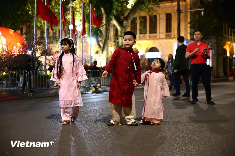 Вечером 29-го дня Тэт — в последний день года Бинь Нго — многие семьи и молодёжь, завершив домашние приготовления, вместе выходят на улицы, чтобы встретить священный момент Новогодней ночи. Фото: Vietnam+.
