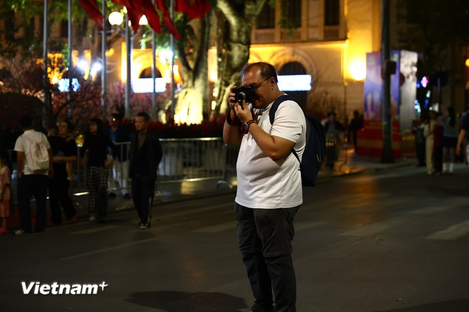 Туристы с интересом запечатлевают повседневные сцены на самой оживлённой пешеходной улице столицы Ханоя. Фото: Vietnam+.