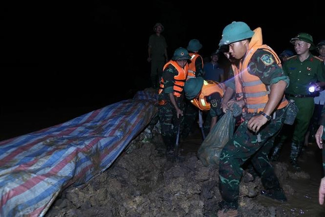 Силы гражданской обороны и военные подразделения продолжают наращивать земляные укрепления, предотвращая перелив воды и обеспечивая безопасность дамбы реки Кау. (Фото: ВИА) 2.jpg