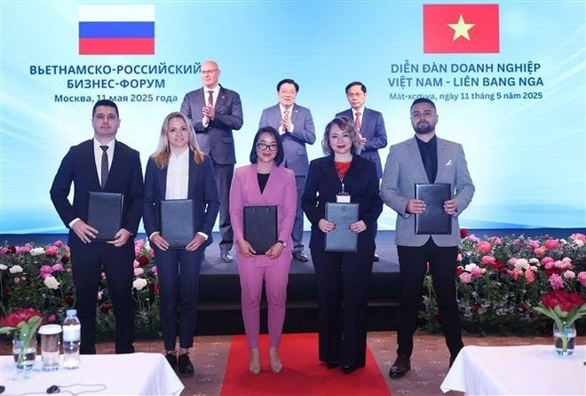 Представители вьетнамского и российского бизнеса обмениваются документами о сотрудничестве на форуме. (Фото: ВИA) 3-8065.png