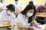 Школьники проверяют личную информацию перед сдачей экзамена по литературе в средней школе Фан Динь Фунг в районе Ба Динь, Ханой утром 7 июля. (Фото: ВИА)