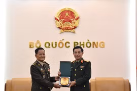 Генерал Фан Ван Зянг вручает памятный подарок генералу Прум Дину. (Фото: qdnd.vn).