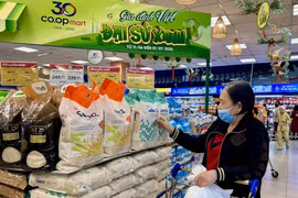 Покупатели приобретают товары в зоне вьетнамской продукции супермаркета Co.opmart Ly Thuong Kiet в городе Хошимине. (Фото: ВИА).