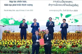 Премьер-министр Фам Минь Тьинь и Премьер-министр Лаоса Сонесай Сипхандон присутствуют при обмене документами о сотрудничестве между предприятиями двух стран. (Фото: ВИА).