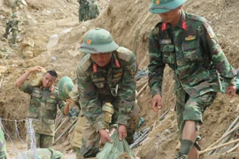 Офицеры и военнослужащие 34-го армейского корпуса прокладывают пути в деревни коммуны Нгоклинь, изолированные из-за ливней и наводнений. (Фото: ВИА)