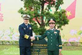 Министр обороны Вьетнама генерал Фан Ван Жанг (справа) и его китайский коллега генерал-полковник Дун Цзюнь сажают памятное дерево на международном пограничном пункте пропуска Монгкай. (Фото: ВИА)