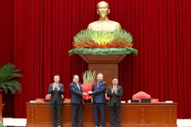 Член Политбюро, Председатель Национального собрания Чан Тхань Ман от имени Центрального комитета вручает цветы и поздравляет товарища То Лама, Генерального секретаря Центрального комитета КПВ XIV созыва. Фото: ВИА