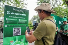 Мужчина сканирует QR-код платформы электронной коммерции VinachemMart во время запуска 10 мая. (Фото: ВИA)