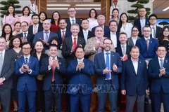 Премьер-министр Фам Минь Тьинь позирует для фото с представителями британского бизнеса. (Фото: ВИA)