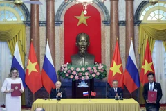 Тогдашний президент государства То Лам (второй справа) и президент России Владимир Путин стали свидетелями обмена подписанными документами между двумя странами по итогам переговоров в Ханое 20 июня 2024 года. (Фото: ВИA)