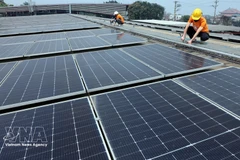 Рабочие устанавливают солнечные панели. Во Вьетнаме зеленый рост и устойчивое развитие определены как стратегические ориентиры социально-экономического развития. Фото: ВИА. 