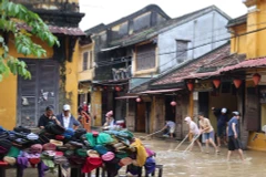 Жители очищают грязь на перекрёстке улиц Нгуен Тхай Хок и Ле Лой в квартале Хойан. (Фото: ВИА)