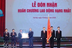 Генеральный секретарь ЦК КПВ То Лам (в центре) вручает орден Труда первой степени газете «Нянзан» в Ханое 11 марта. (Фото: ВИA)