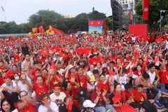 Толпа жителей в красных флагах с желтыми звездами заполняет перекресток Хынг Выонг – Чан Фу в ожидании второй полной репетиции (Фото: ВИA)