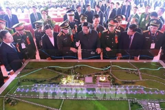 Премьер-министр Фам Минь Тьинь (на переднем плане, четвертый справа) и официальные лица рассматривают модель проекта аэропорта Жабинь (Фото: ВИA)