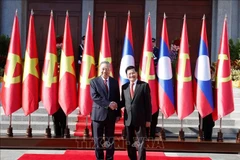 Генеральный секретарь, Президент Лаоса Тхонглун Сисулит приветствует Генерального секретаря То Лама. (Фото: ВИА).