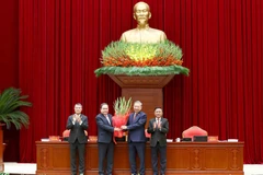 Член Политбюро, Председатель Национального собрания Чан Тхань Ман от имени Центрального комитета вручает цветы и поздравляет товарища То Лама, Генерального секретаря Центрального комитета КПВ XIV созыва. Фото: ВИА