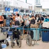 Пассажиры проходят регистрацию на рейс в Международном аэропорту Нойбай. (Фото: Vietnam+)