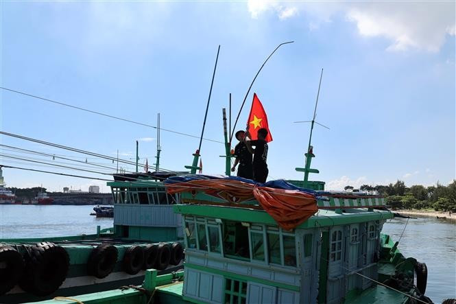 Офицеры и бойцы Пограничного поста Сонча (Командование Пограничных войск города Дананг) передают Государственный флаг рыбакам (Фото: ВИА)