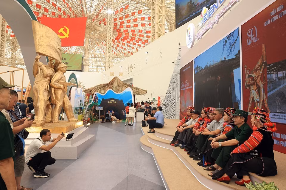 Посетители фотографируются на память вместе с представителями народа Ханьи на стенде провинции Дьенбьен (Фото: ВИА)