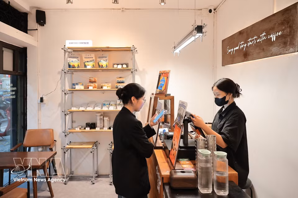 Граждане используют QR-код для оплаты в магазине напитков на улице Фан-хюи-чу (Ханой) (Фото: ВИА)