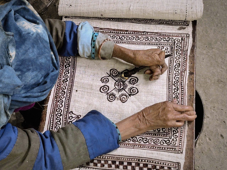 Нанесение узоров пчелиным воском на грубое тканое полотно