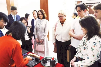 Иностранные гости с удовольствием знакомятся с искусством печати с деревянных клише. (Фото: nhandan.vn) 