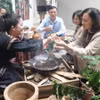 Туристы знакомятся с традиционным способом обжарки кофе народа Эдэ (Фото: nhandan.vn)