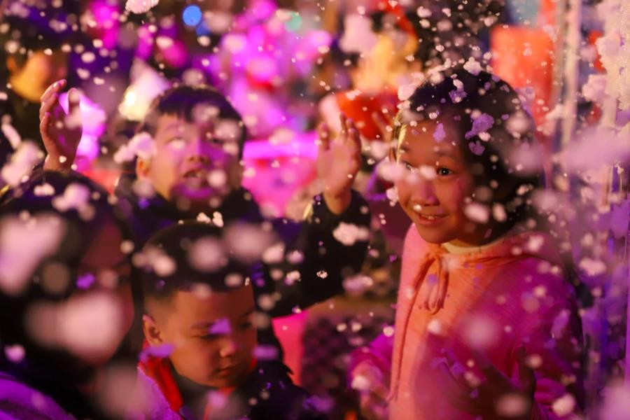 Сегодня вечером на пешеходной улице Чан Нян Тонг (Хай Ба Чынг, Ханой) люди, особенно дети, могли «полюбоваться, как падает снег» в рождественскую ночь. (Фото: Vietnam+)