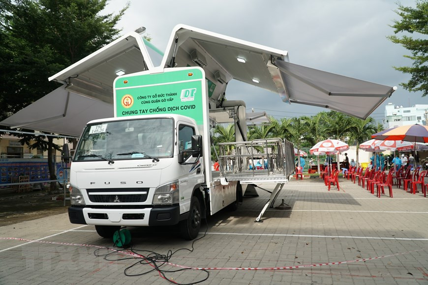 Люди получают вакцинацию против COVID-19 в мобильном пункте вакцинация у народного комитета района Говап, Хошимин. (Фото: ВИА)