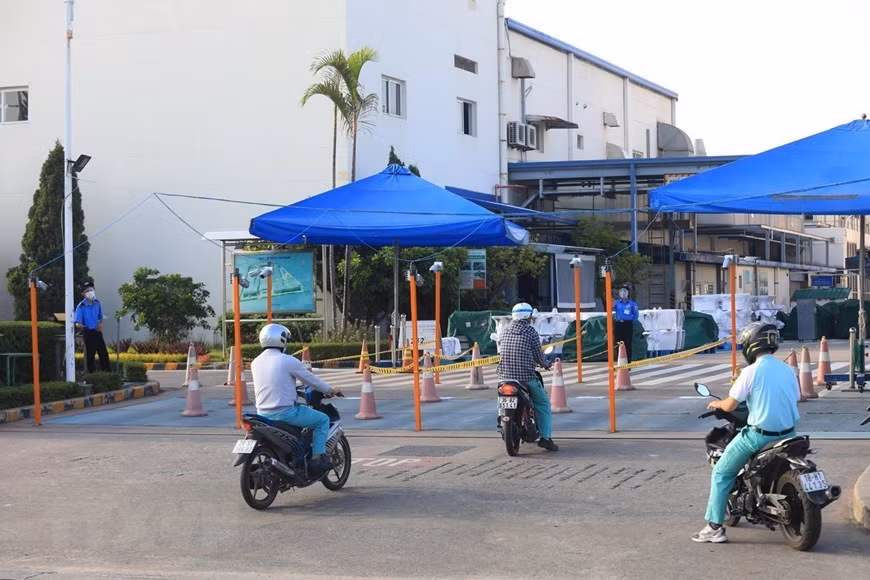 Рабочие, приезжающие на работу в компанию TOTO Vietnam, промышленный парк Тханг Лонг - Ханой, должны следовать по разделенным полосам. (Фото: ВИА)