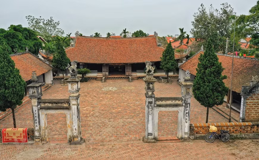 Ворота в дом состоит из четырех квадратных столбов, построенных из кирпича. На вершине больших столбов сидят два льва, а на маленьких столбов - цветочные горшки. На трех цилиндрических гранях столба гравюрированы китайские иероглифы. (Фото: Суан Май / Vietnam +)