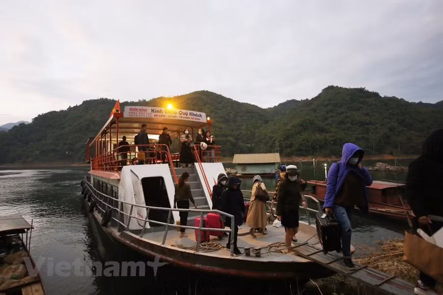 Пассажиры совершают морскую прогулку по водохранилищу Хоабинь перед тем, как причалить к деревне Дабиа. Деревня этнических меньшинств станет частью национальной туристической зоны водохранилища Хоабинь, которая находится в стадии развития до 2035 года в соответствии с решением премьер-министра от 25 марта 2021 года. Общая площадь национальной туристической зоны составит 52.200 га и займет весь город Хоабинь, столицу провинции, и части четырех районов Дабак, Каофонг, Танлак и Майчау. Ожидается, что к 2035 году местность будет принимать около 130.000-145.000 жителей и ежегодно принимать около 2,5-3 миллионов посетителей. Дом на сваях, который использовался в качестве дома для проживания в деревне Дабиа, в окружении множества деревьев и цветущих растений. (Фото: Вьетнам+) 