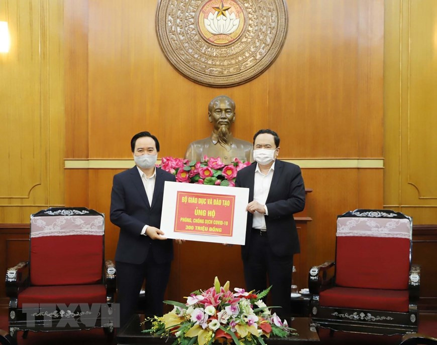 Секретарь ЦК Компартии и председатель ЦК Отечественного фронта Вьетнама Чан Тхань Ман принимает пожерствование Министерства образования и профессиональной подготовки от министра Фунг Суан Нья. (Фото: Фыонг Хоа / ВИА)