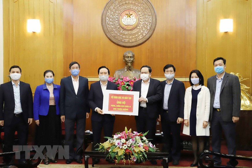 Секретарь ЦК Компартии и председатель ЦК Отечественного фронта Вьетнама Чан Тхань Ман принимает пожерствование Министерства образования и профессиональной подготовки от министра Фунг Суан Нья. (Фото: Фыонг Хоа / ВИА)