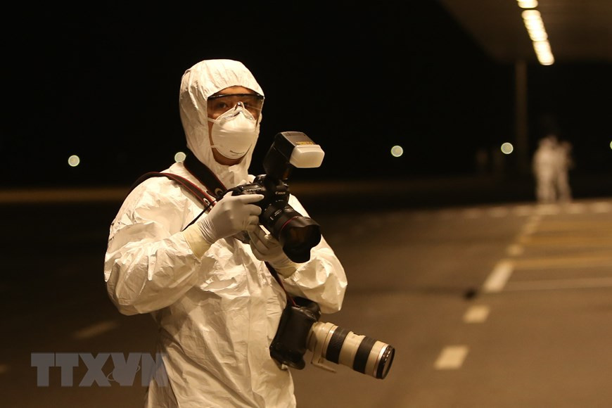 Фотокорреспондент Зыонг Жанг снимает мероприятие приема группы из 30 вьетнамских граждан из Ухани (Китай) в аэропорту Вандон (Куангнинь) утром 10 февраля 2020 года. (Источник: ВИА)