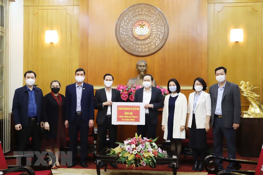 Секретарь ЦК Компартии и председатель ЦК Отечественного фронта Вьетнама Чан Тхань Ман принимает пожерствование от Союза вьетнамских кооперативов. (Фото: Фыонг Хоа / ВИА)