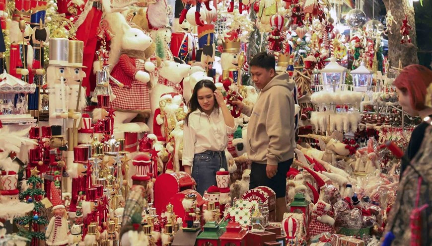 Молодые люди покупают рождественские украшения на улице Хангма в Ханое. (Фото: ВИА)
