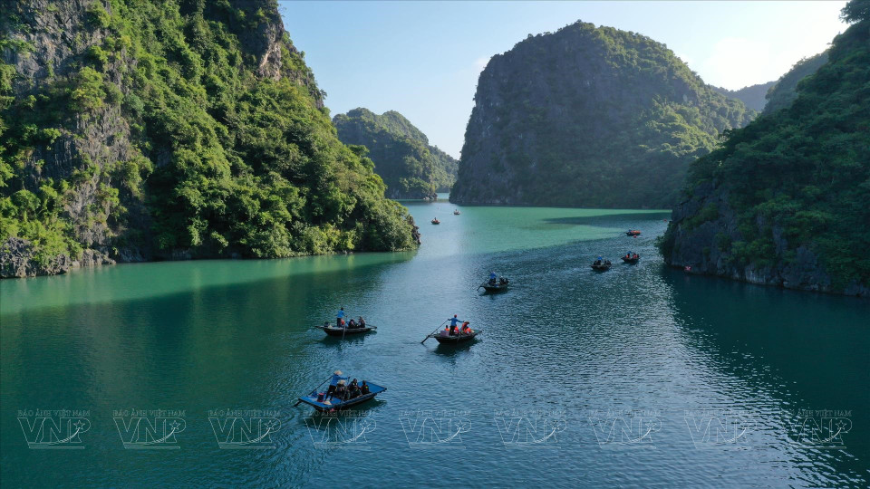 Туристы садятся в лодку в заливе Ланха, чтобы посетить и исследовать «Яркую» и «Темную» пещеры. (Фото: ВИА)