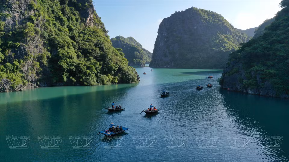 Туристы садятся в лодку в заливе Ланха, чтобы посетить и исследовать «Яркую» и «Темную» пещеры. (Фото: ВИА)