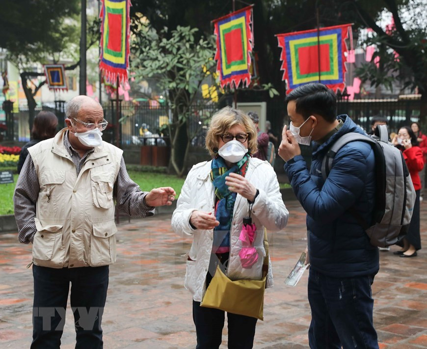 Посетители Храма Литературы носят маски для лица, чтобы предотвратить острое респираторное заболевание, вызванное новым коронавирусом (Фото: ВИА)