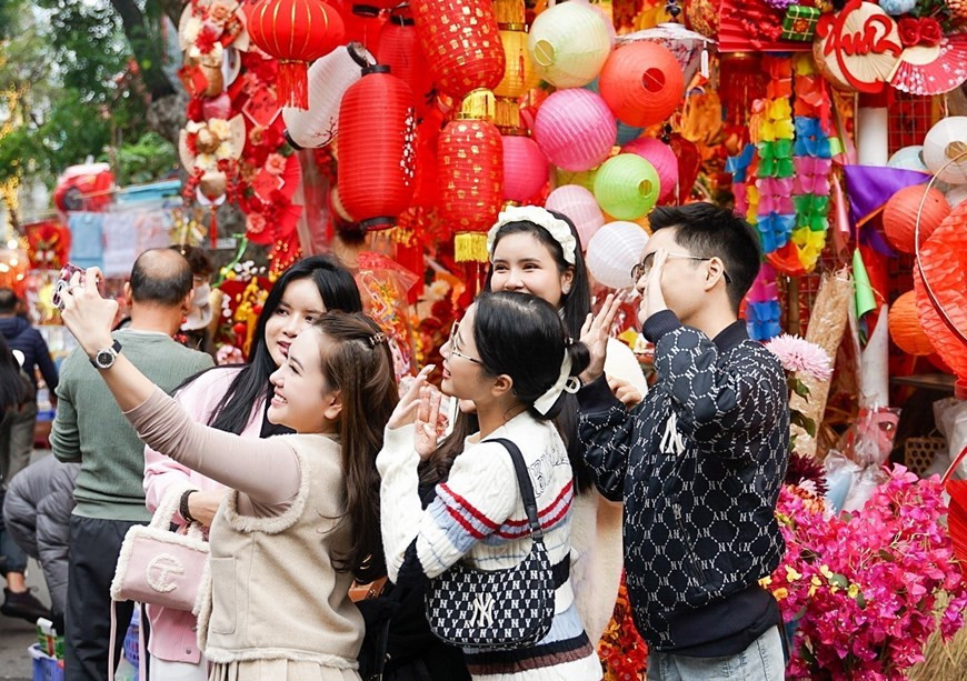 Традиционный цветочный рынок Тэт на улице Ханглыок в Старом квартале Ханоя продолжает привлекать значительное количество молодых людей, предлагая им возможность отпраздновать Лунный Новый год и уловить суть первых моментов года. (Фото: ВИА)