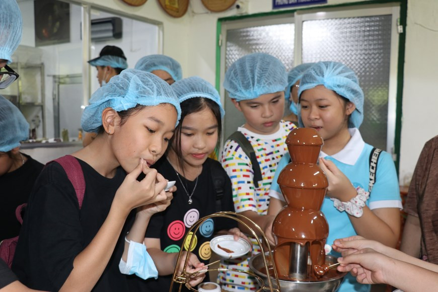 Юные туристы с удовольствием пробуют свежий шоколад, произведенный на шоколадной фабрике Alluvia. (Фото: ВИА)