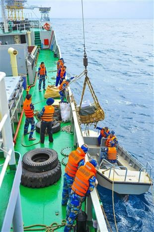 Должностные лица и солдаты перегружают грузы на платформу ДК1 / 15 (Фото: ВИА)