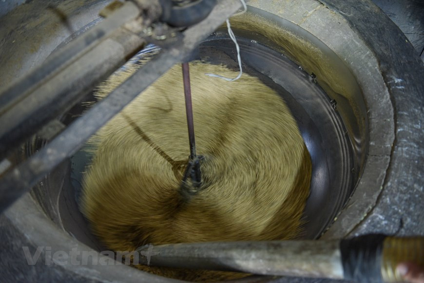 Жарка «ком» - один из важных этапов обработки, требующая от мастера большого опыта. Осенью почти все жители деревень Мечи и Вонг от молодых до стариков собираются вместе, чтобы готовить молодой клейкий рис «ком». Каждому человеку поручают заниматься определенным этапом приготовления в соответствии со своим возрастом. Традиционо жарить «ком» на дровах, а не древесном угле, в течении 2 часа. Во время процесса обжарки должны следить за огнем, постоянно регулируя огонь, чтобы рис не был недожаренным или наоборот пережаренным. Мастера оычно определить готовность «ком» руками. Сначала жарить рис на большом, а потом постепенно уменьшая огонь. В настоящее время рис жарить уже на оборудовании, что сокращает рабочую силу. Обычно 10 кг риса дает 1,6-1,7 кг «ком». (Фото: Vietnam+) 