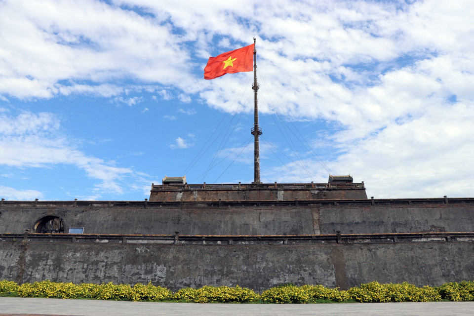 Красный флаг с желтой звездой развевается над флагштоком на площади Нго Мон. (Фото: ВИА)